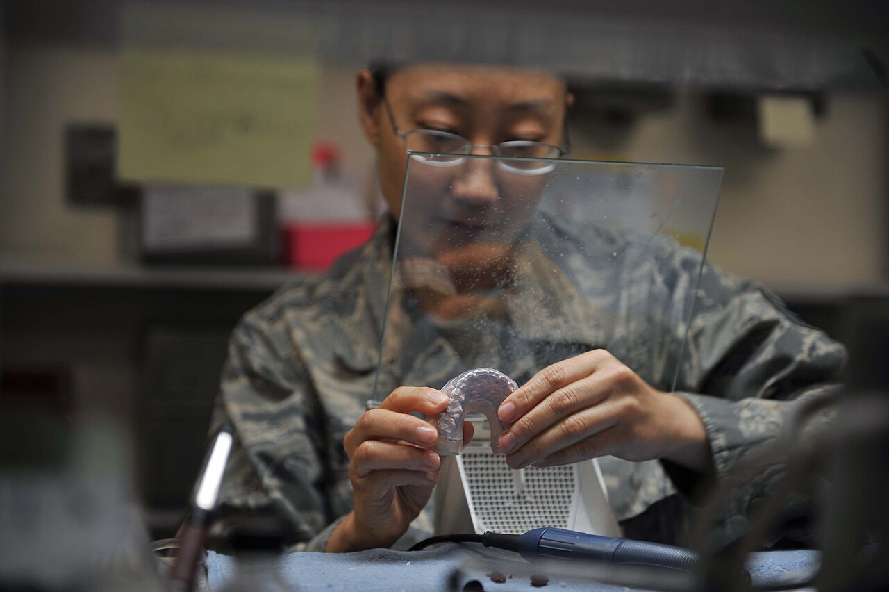 Dental technician finishing a clear aligner in the lab