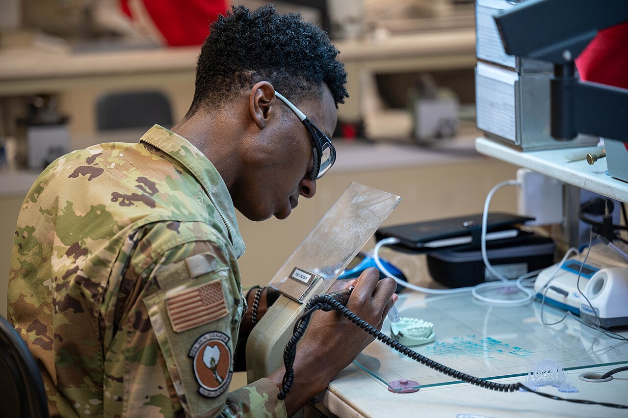 Dental technician preparing a clear aligner tray in the lab